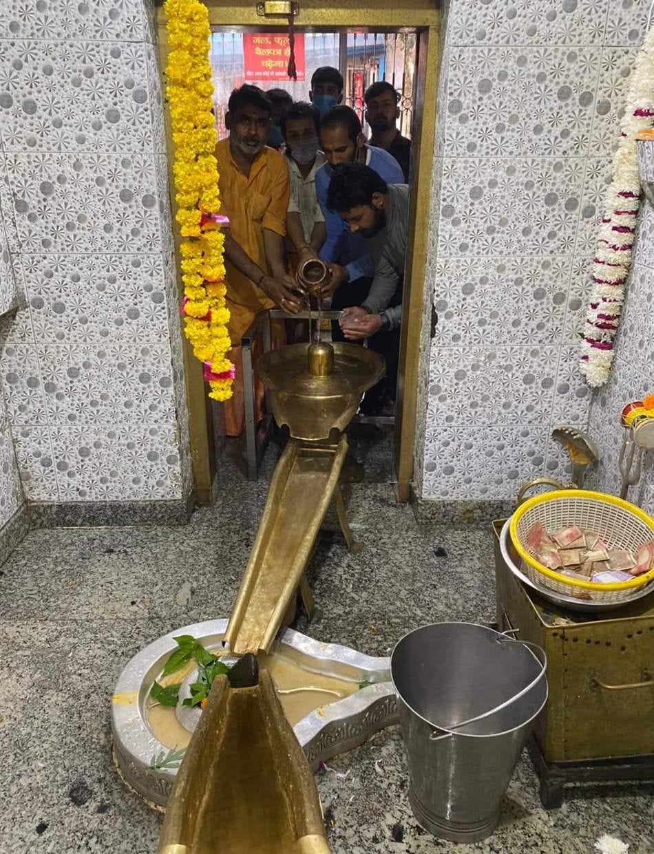 नीलकंठ महादेव मंदिर में जलाभिषेक करते शिवभक्त। नीलकंठ महादेव मंदिर में जलाभिषेक करते शिवभक्त।