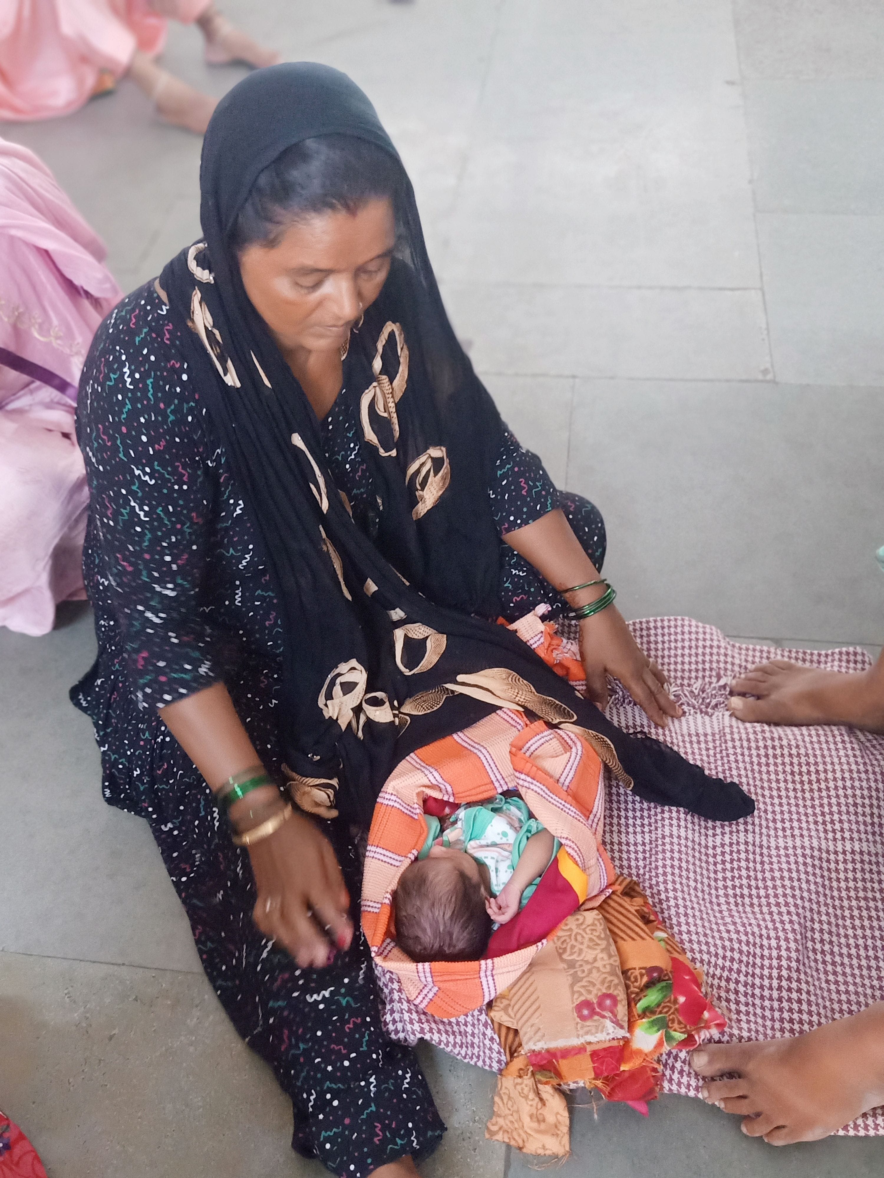 Three patients on one bed, mothers sit on the floor with the baby in their lap
