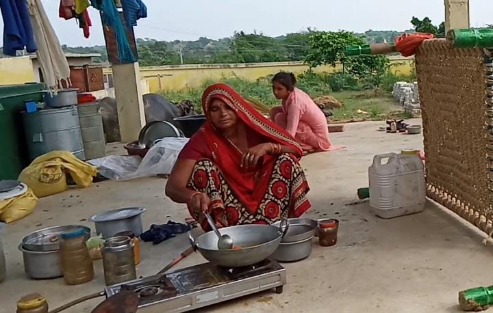 फोटो संख्या 20  बाढ़ के बाद घर पहुंचा परिवार खुले में खाना बनाती महिला।