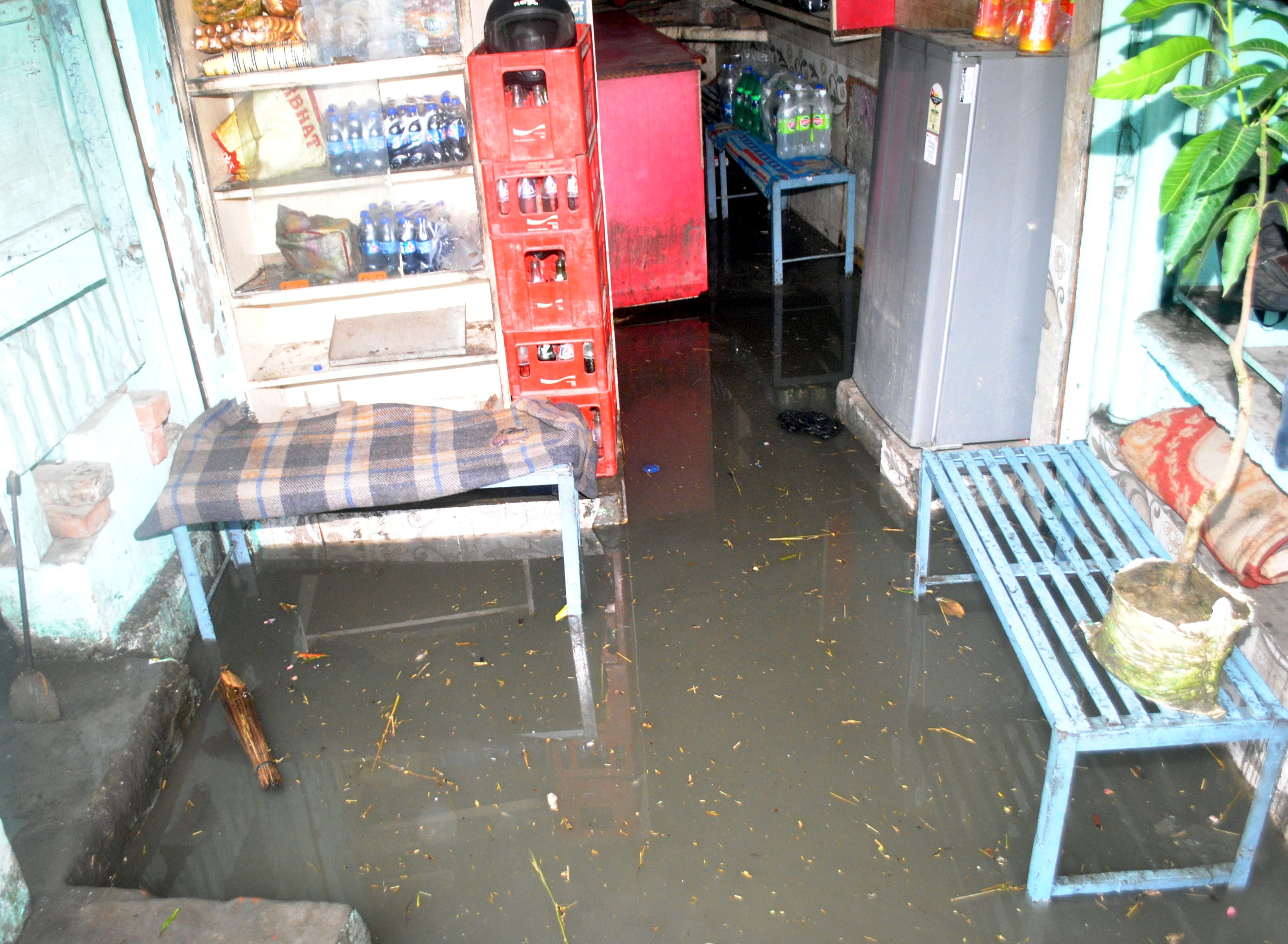 बरसात से चाय की दुकान में भरा पानी। बरसात से चाय की दुकान में भरा पानी।