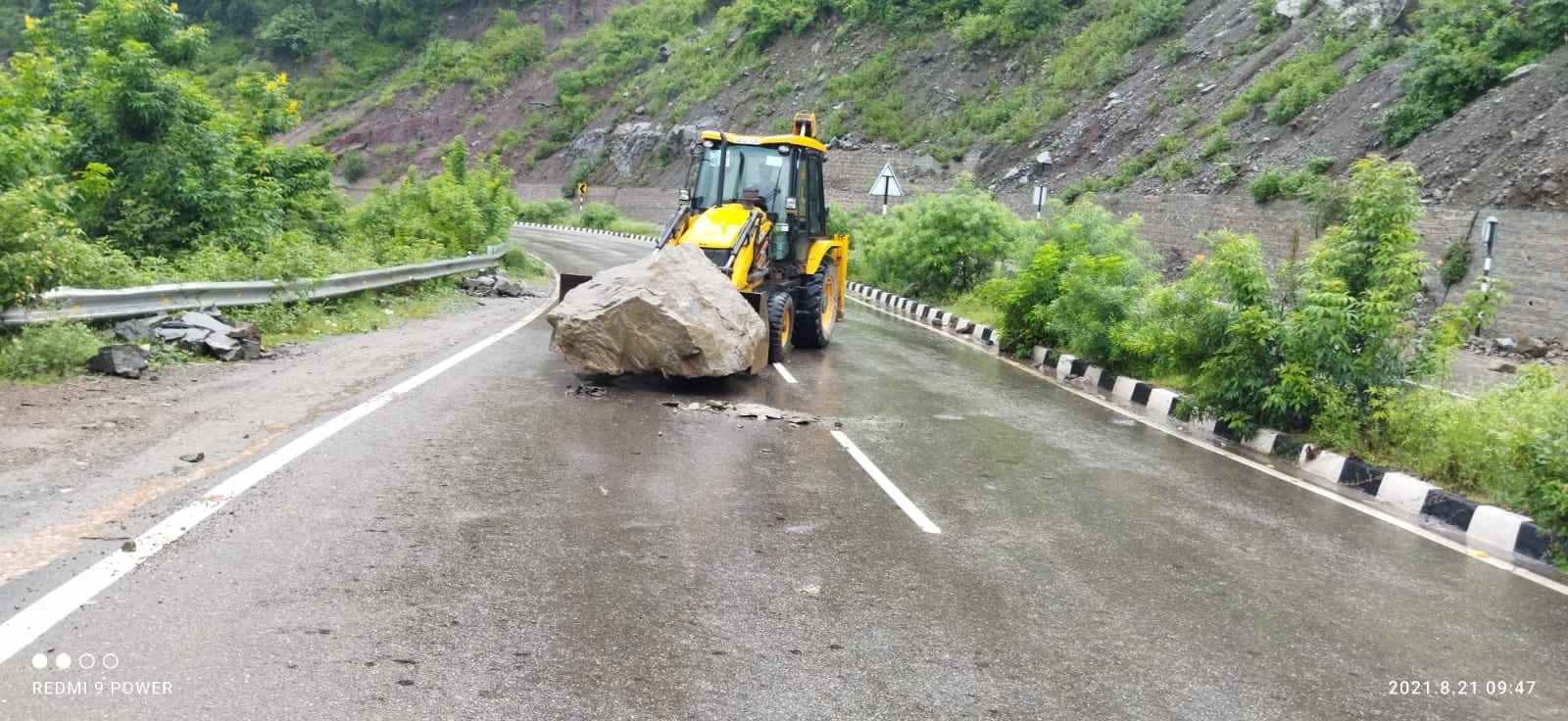 कालका-शिमला एनएच पर गिरे पत्थर को हटाती जेसीबी। संवाद कालका-शिमला एनएच पर गिरे पत्थर को हटाती जेसीबी। संवाद
