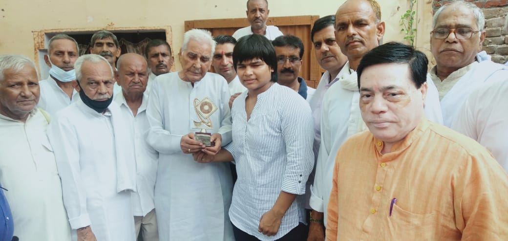 मंसूरपुर के गांव पुरबालियान में महिला पहलवान दिव्या काकरान को ट्रॉफी देकर सम्मानित करते ग्रामी?