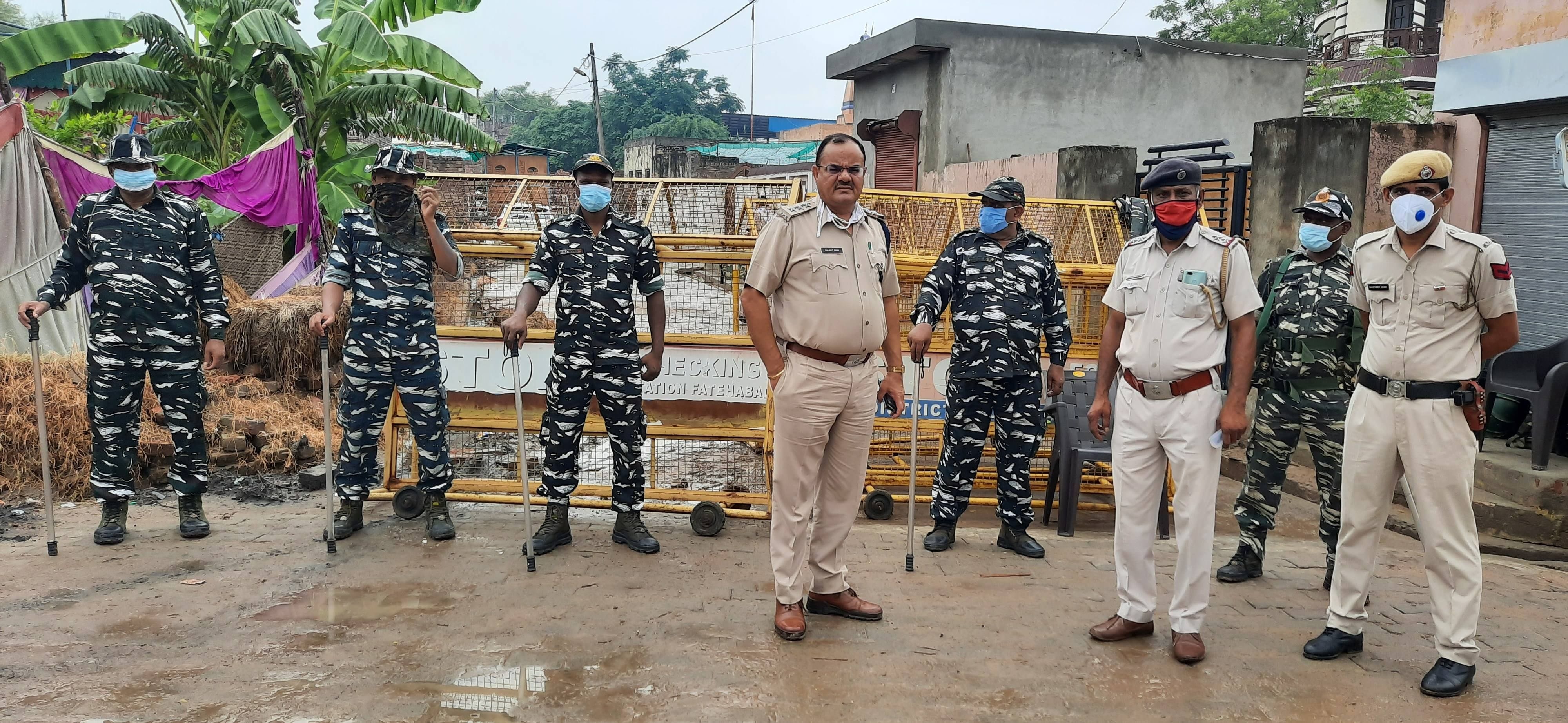 गांव बुवान की बैरिकेडिंग करके सील की हुई गली और मौजूद पुलिस अधिकारी व फोर्स।