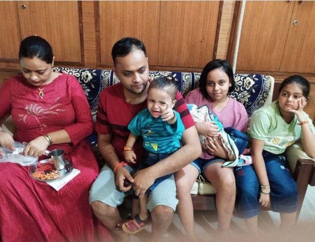 एक दूसरे को राखी बांधते परिवार के सदस्य। 