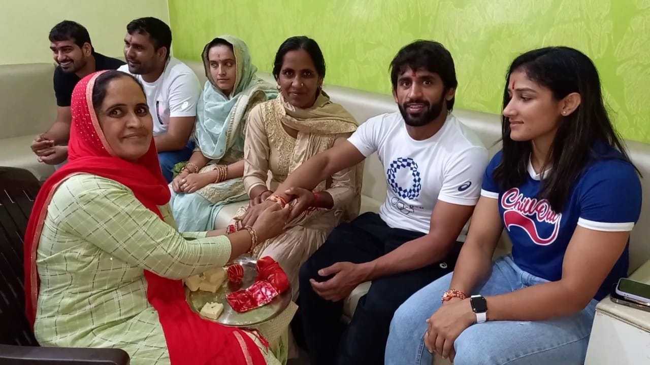  ओलंपिक में कांस्य पदक विजेता पहलवान बजरंग पूनिया को राखी बांधती बहन गायत्री व सुशीला, साथ बैठी ब?