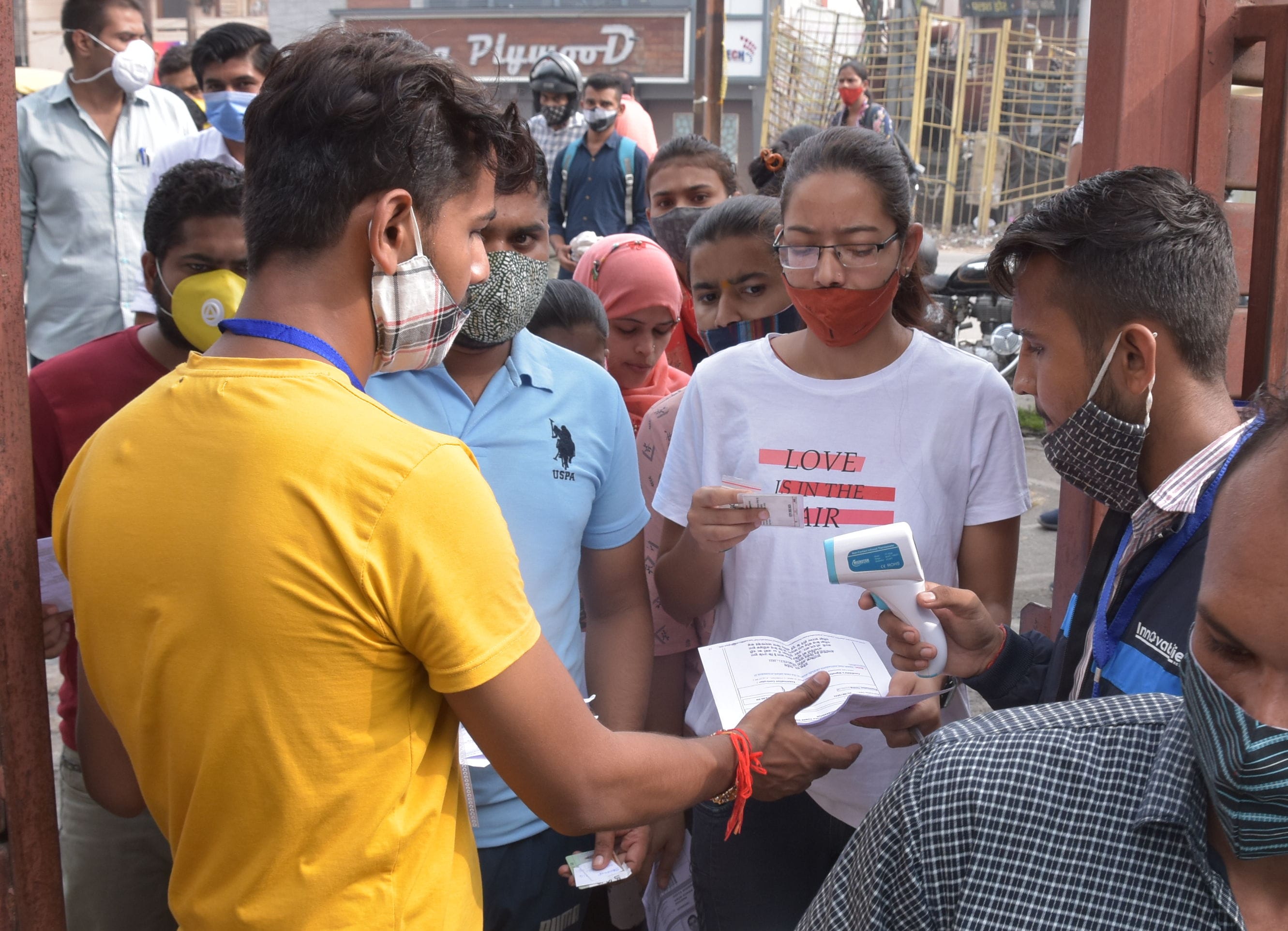 एसएएम इंटर कॉलेज से पीईटी परीक्षा देने पहुंचे परीक्षार्थी की चेकिंग करते एजेंसी के कर्मी