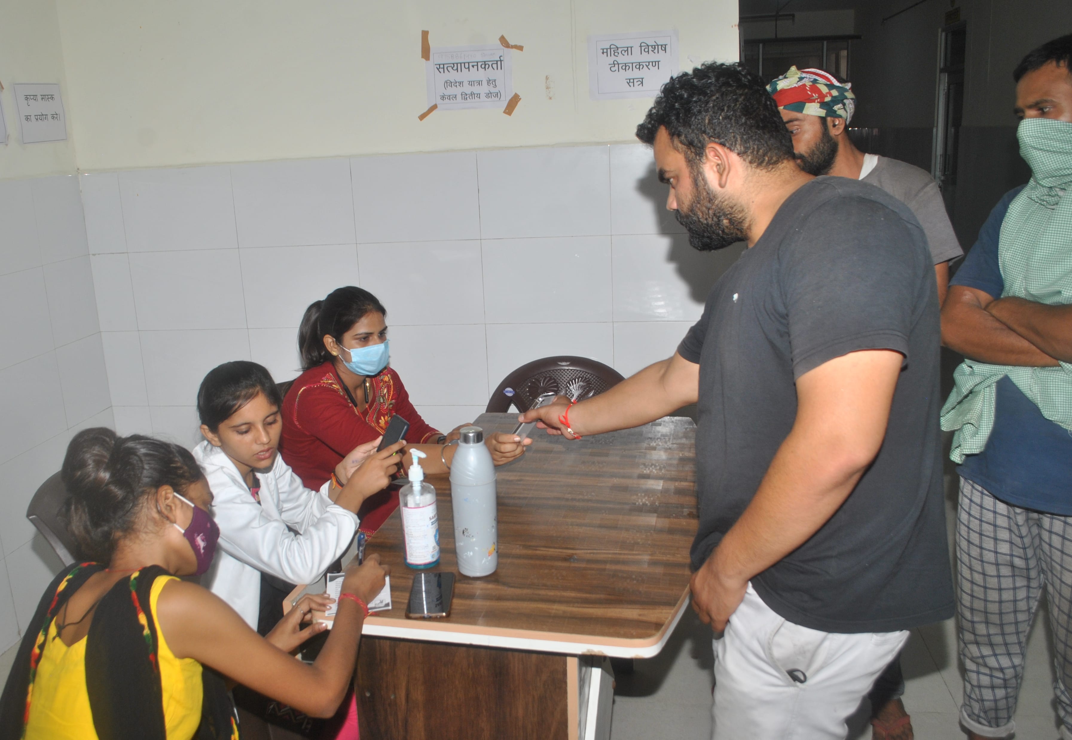शामली जिला अस्पताल में टीका लगवाने से पहले आईडी चेक करवाते लोग। शामली जिला अस्पताल में टीका लगवाने से पहले आईडी चेक करवाते लोग।