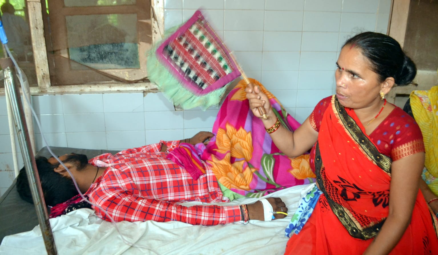 अस्पताल में बीमार युवक को हाथ का पंखा करती मां। संवाद अस्पताल में बीमार युवक को हाथ का पंखा करती मां। संवाद