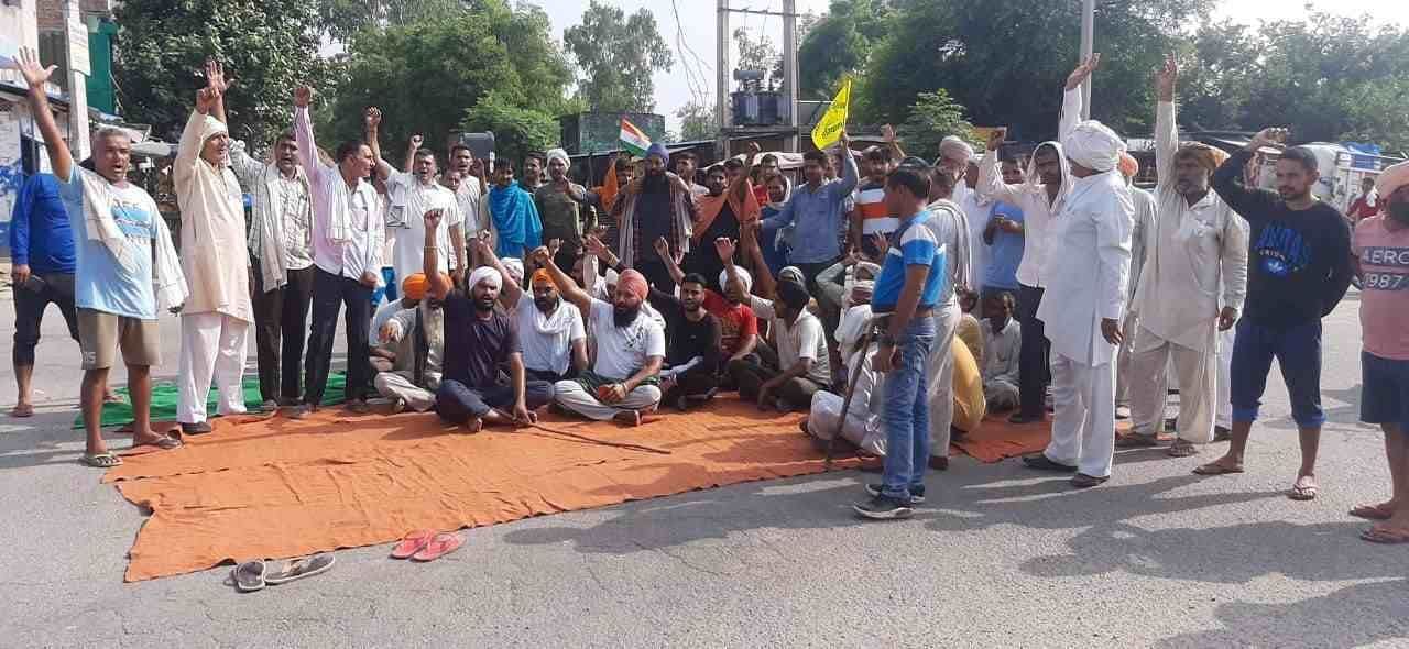  अलेवा में सड़क के बीच बैठकर जाम लगाते किसान। संवाद