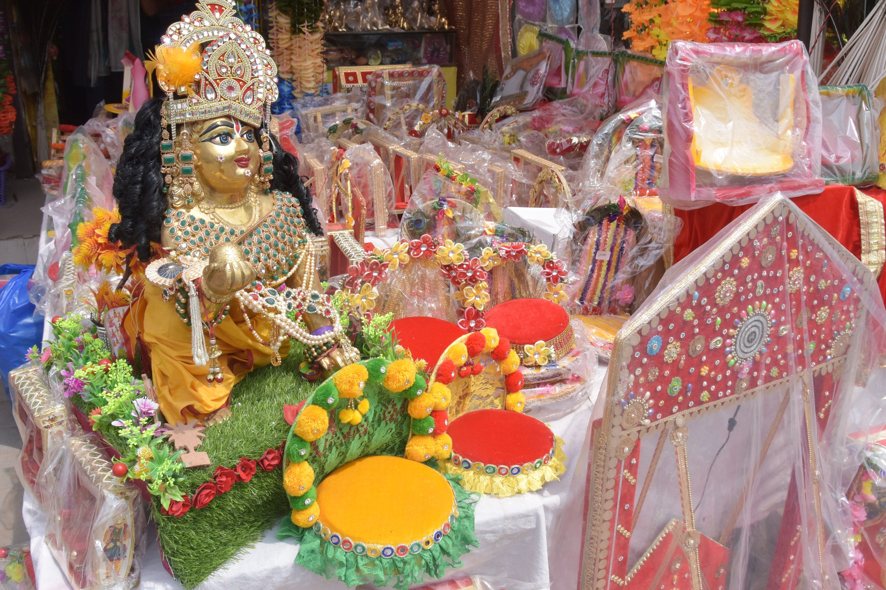 श्री कृष्ण जन्माष्टमी के उपलक्ष्य में बाजार में दुकान पर लड्डू गोपाल व अन्य सामान।