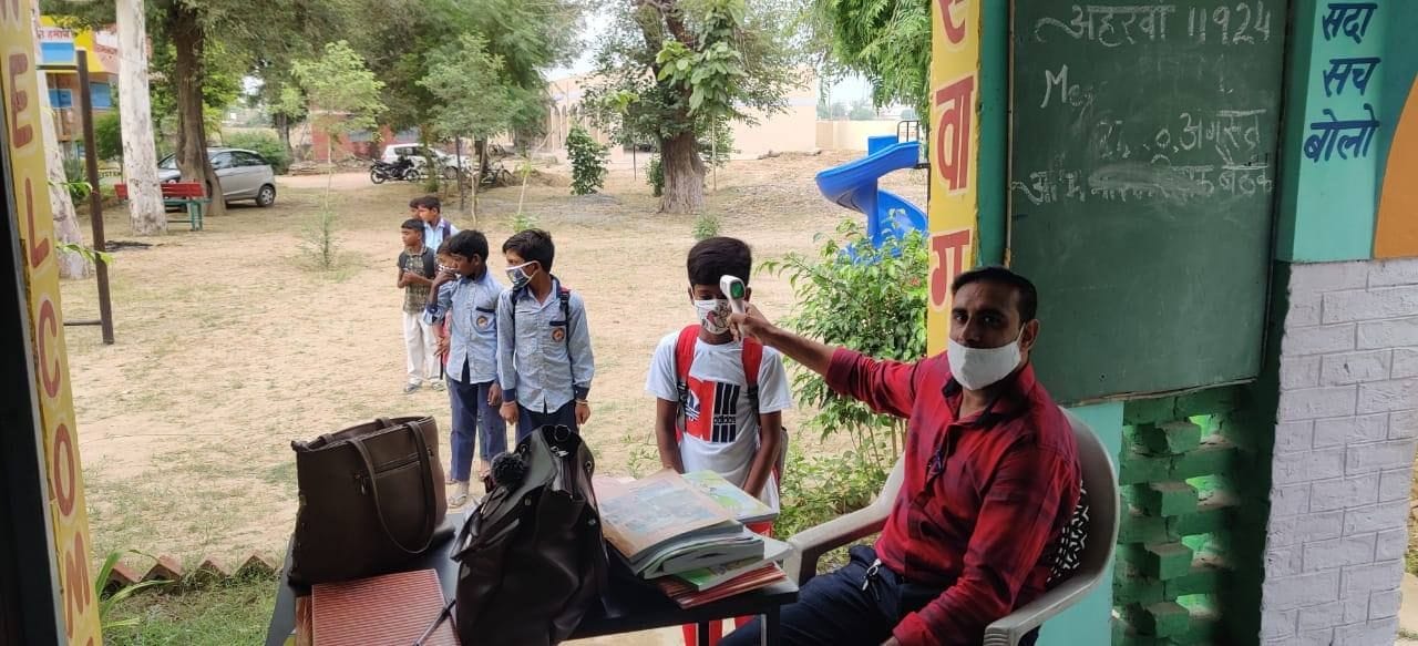 स्कूल में विद्यार्थियों की थर्मल स्क्रीनिंग करते शिक्षक। स्कूल में विद्यार्थियों की थर्मल स्क्रीनिंग करते शिक्षक।