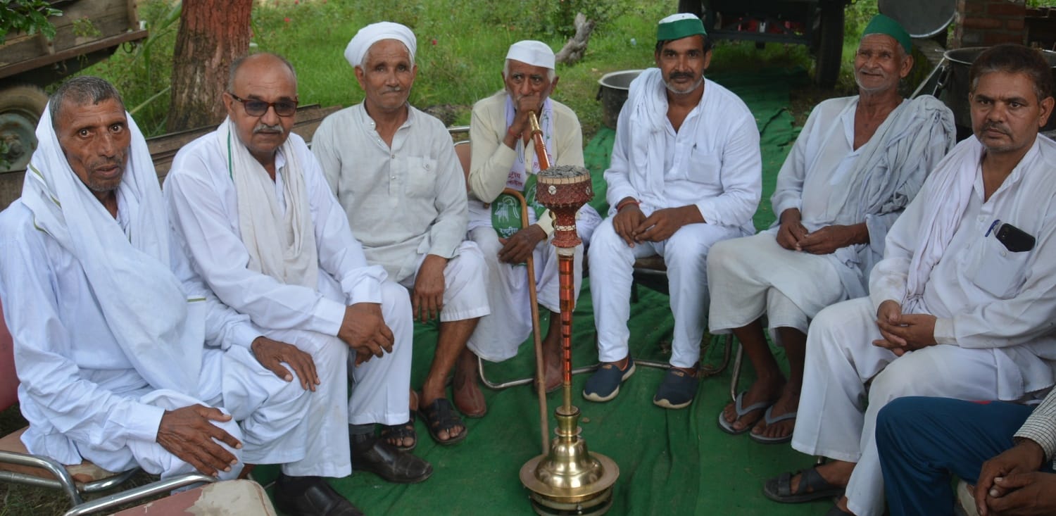 मुजफ्फरनगर में सरकुलर रोड पर हुक्का गुड़गुड़ाते किसान। मुजफ्फरनगर में सरकुलर रोड पर हुक्का गुड़गुड़ाते किसान।