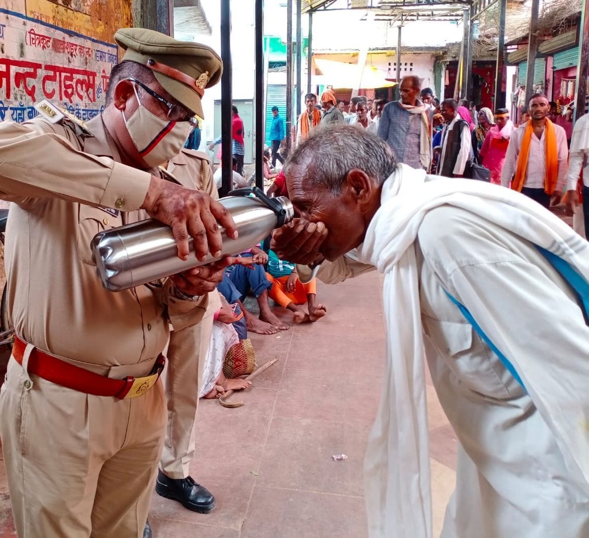 अमावस्या मेले में प्यासे श्रद्घालु को परिक्रमा मार्ग पर पानी पिलाते दरोगा। संवाद अमावस्या मेले में प्यासे श्रद्घालु को परिक्रमा मार्ग पर पानी पिलाते दरोगा। संवाद