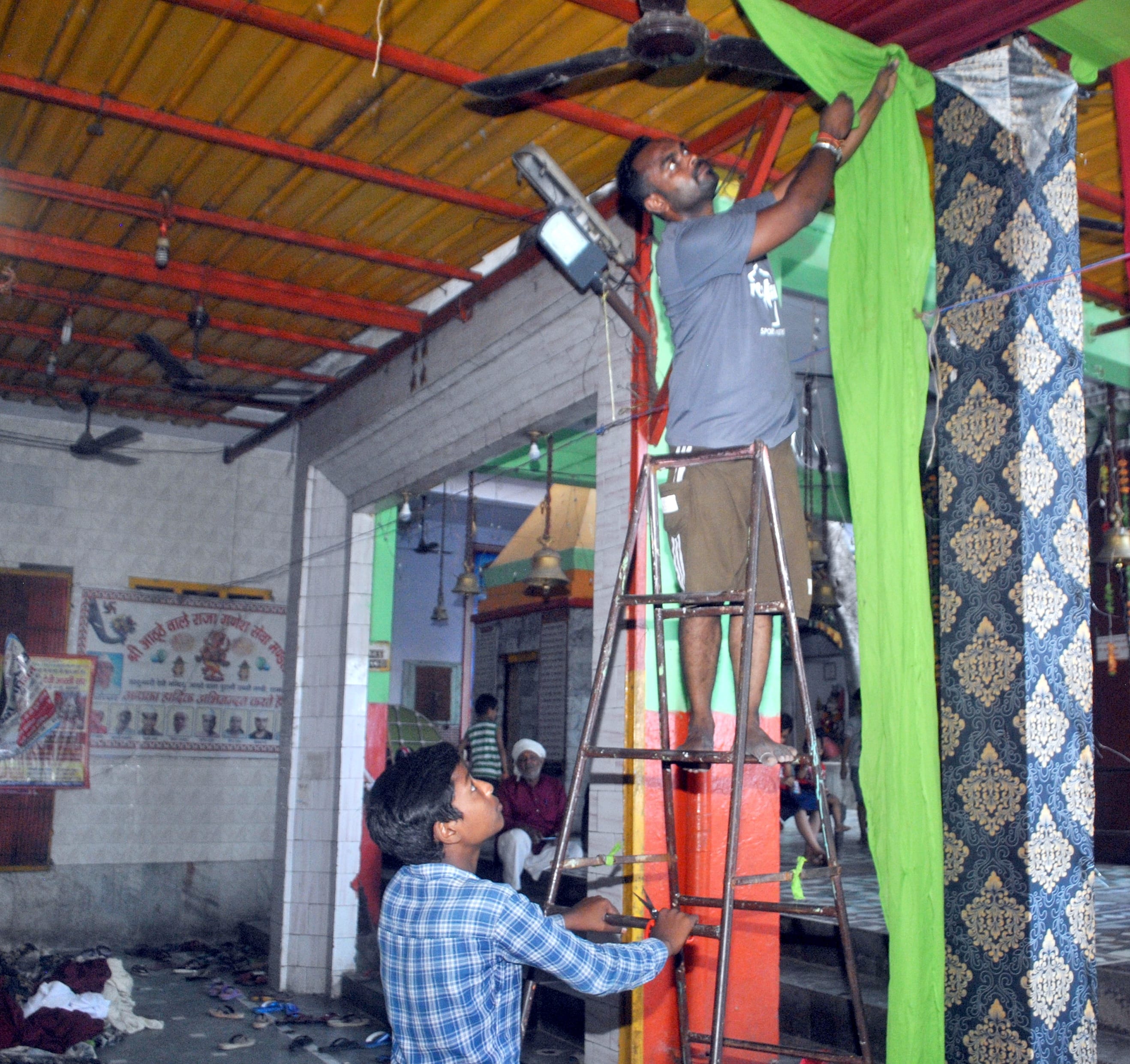 शामली  आठठे वाला मन्दिर में गणेश महोत्सव पर तैयारी करते कर्मचारी