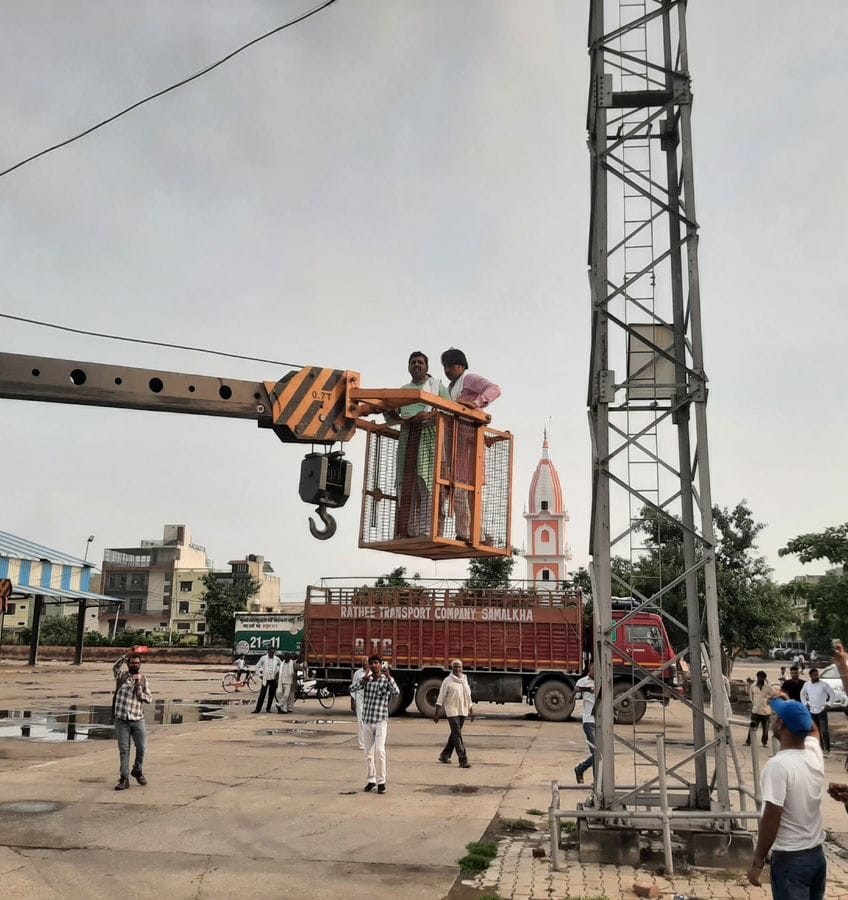 समालखा।  समालखा अनाज मंडी में टावर पर चढ़े किसान को क्रेन से उतारते हुए।