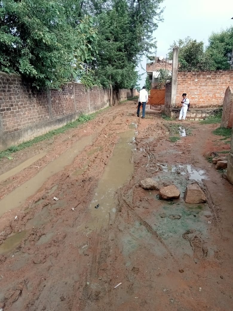 गली में मचे कीचड़ से बचकर निकलता स्कूल का बच्चा