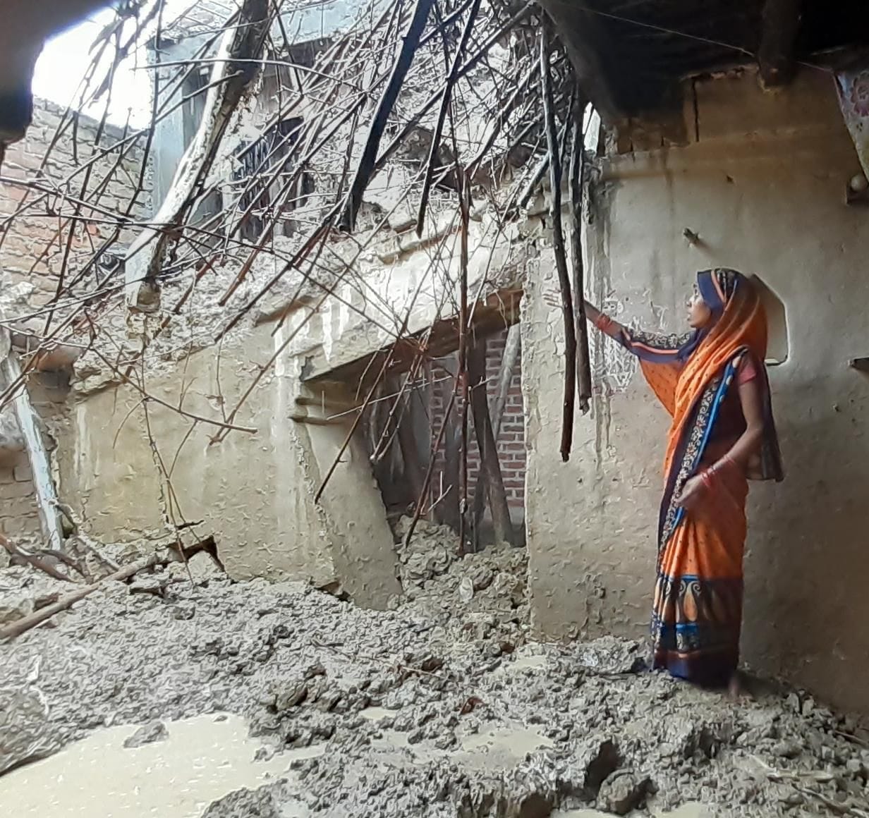 औरास के मिर्जापुर अजिगांव में बरसात से गिरी छत दिखातीं महिला। संवाद औरास के मिर्जापुर अजिगांव में बरसात से गिरी छत दिखातीं महिला। संवाद