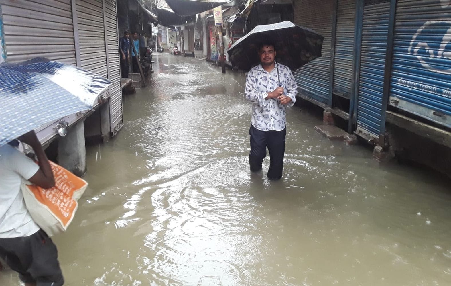 शहर के मोहल्ला रस्तोगी में भरे बारिश के पानी से गुजरता युवक। संवाद शहर के मोहल्ला रस्तोगी में भरे बारिश के पानी से गुजरता युवक। संवाद