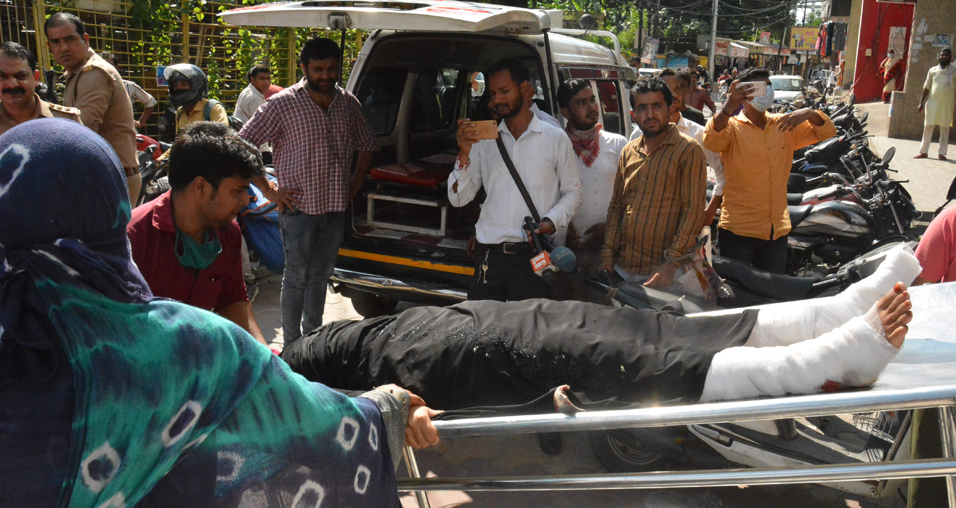 मुजफ्फरनगर के ओवरसीज बैंक में गोली चलने में घायल महिला को एंबुलेंस से ले जाते लोग। मुजफ्फरनगर के ओवरसीज बैंक में गोली चलने में घायल महिला को एंबुलेंस से ले जाते लोग।