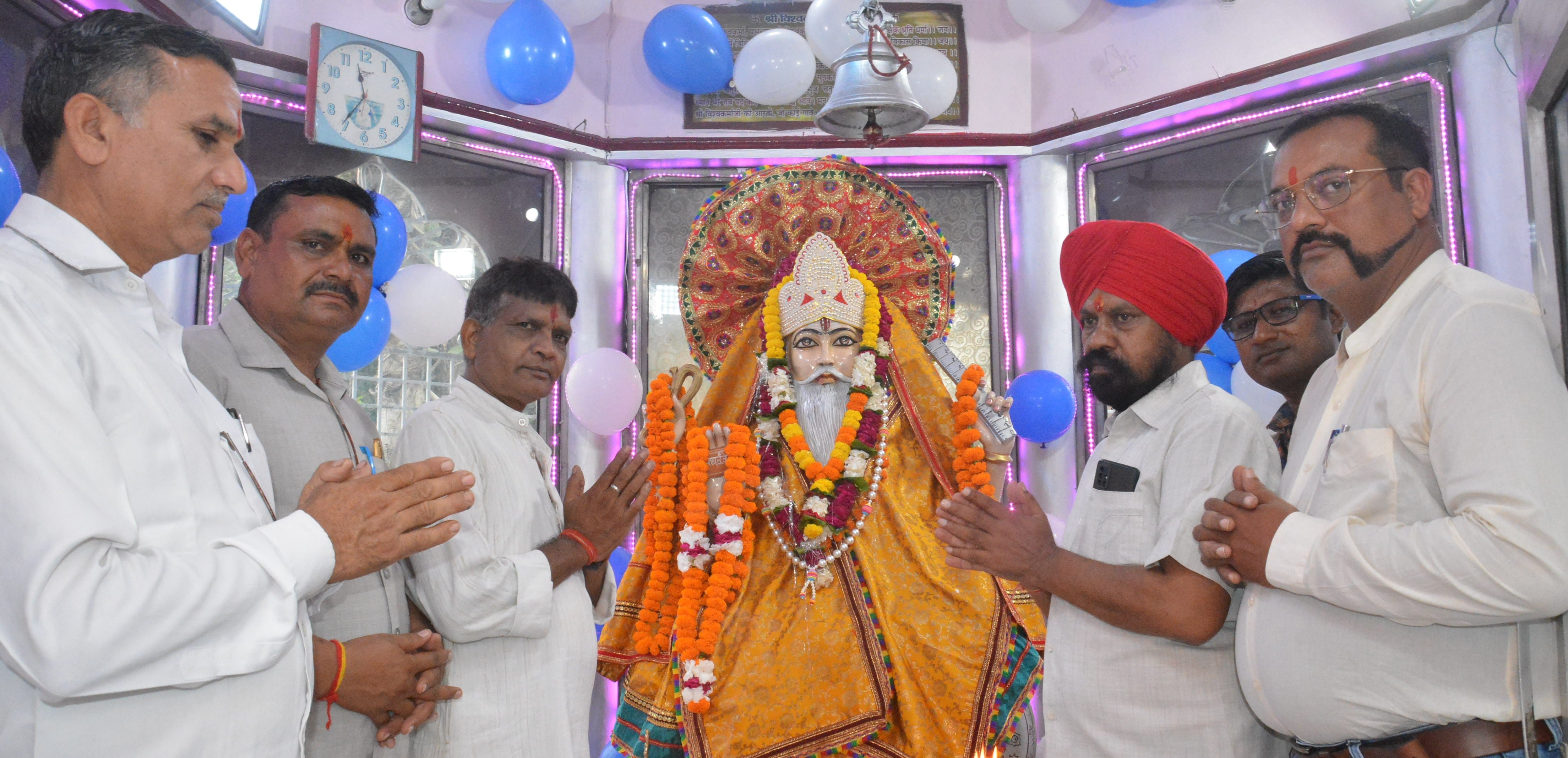 विश्वकर्मा जंयती पर भगवान विश्वकर्मा मूर्ति  पर पूजा अर्चना करते समाज के लोग।