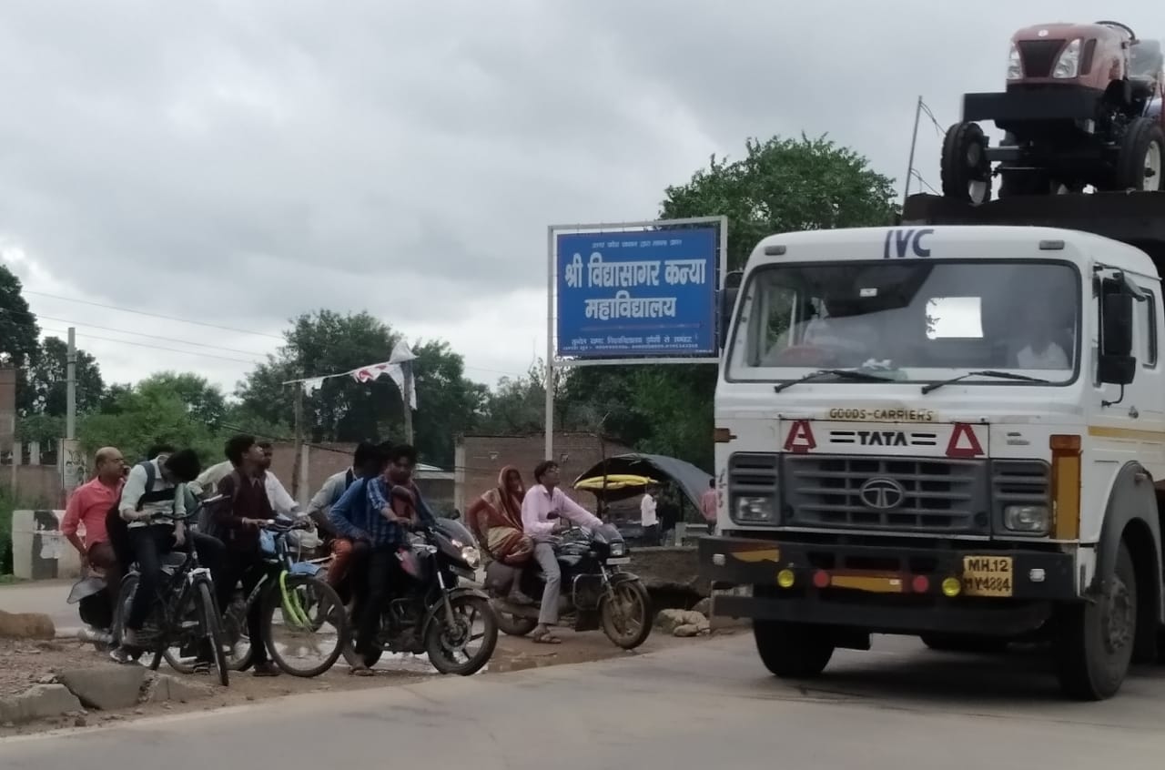 हाईवे पर टूटे डिवाइडर से निकलते लोग हाईवे पर टूटे डिवाइडर से निकलते लोग