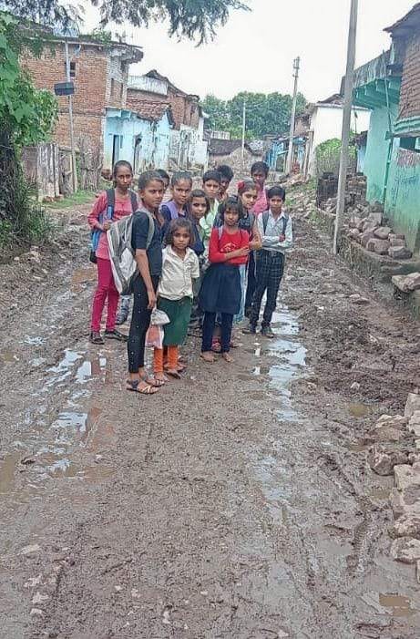 दलदल से निकलकर स्कूल जाते बच्चे