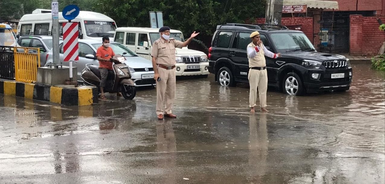 बारिश में शहर की यातायात व्यवस्था को संभालते हुए पुलिसकर्मी। बारिश में शहर की यातायात व्यवस्था को संभालते हुए पुलिसकर्मी।