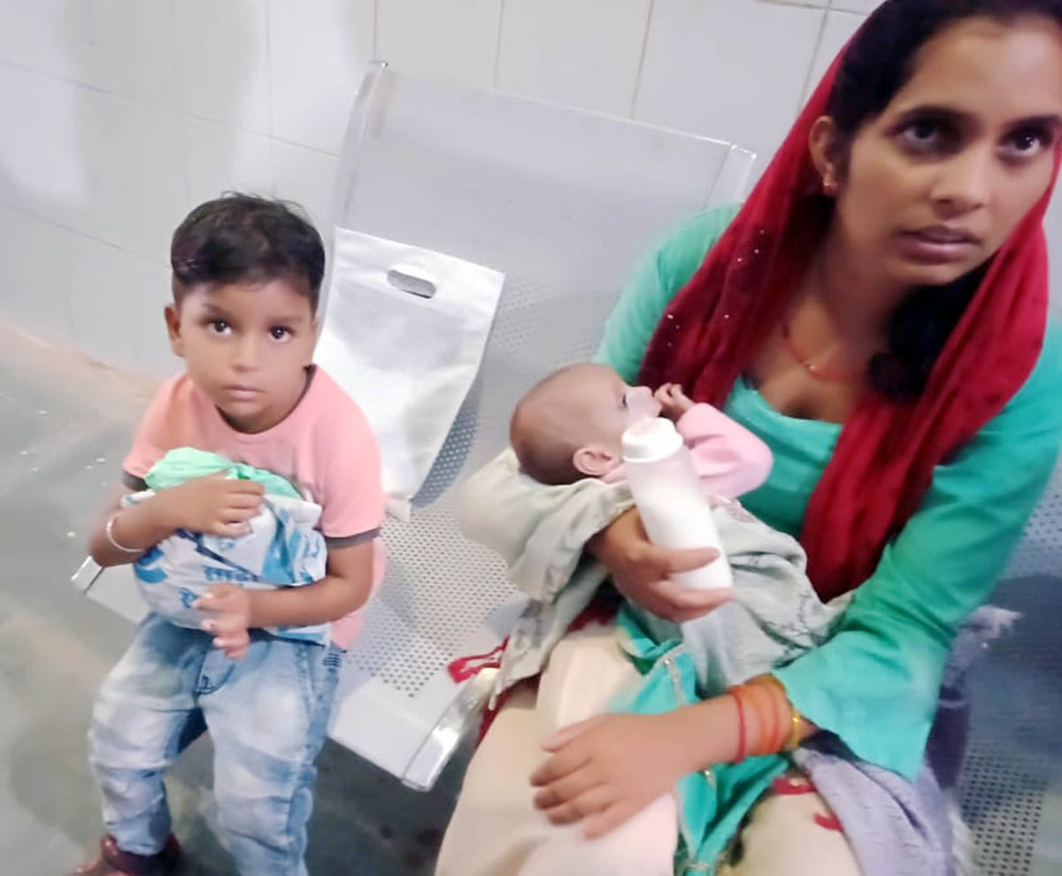 मौदहा सीएचसी में मासूम बच्चे को लिए महिला।