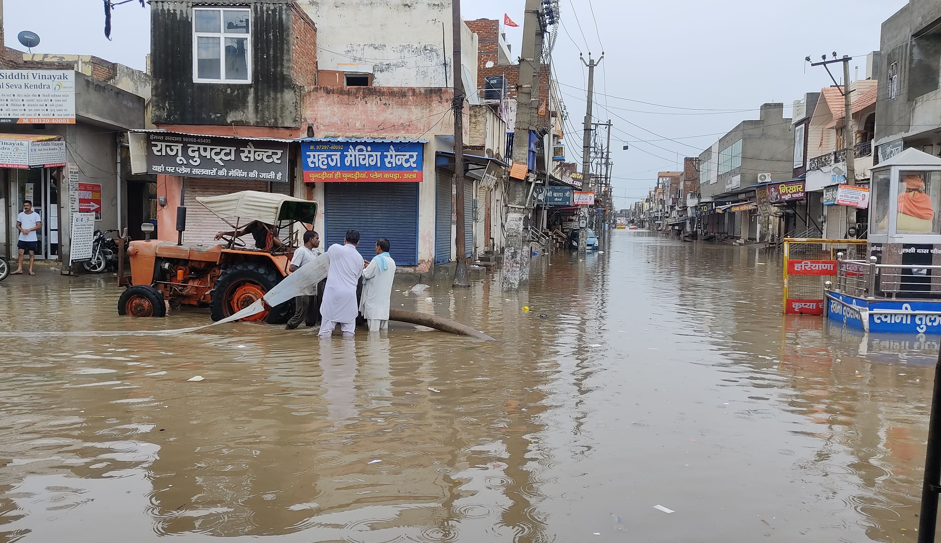 तुलसीदास चौक पर पानी की निकासी के लिए पंपसेट लगाते हुए जनस्वास्थ्य विभाग के कर्मचारी।
