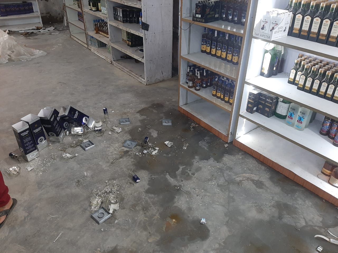 उत्सव गार्डन में शराब ठेके में लूट के दौरान फायरिंग से टूटी बोतलें