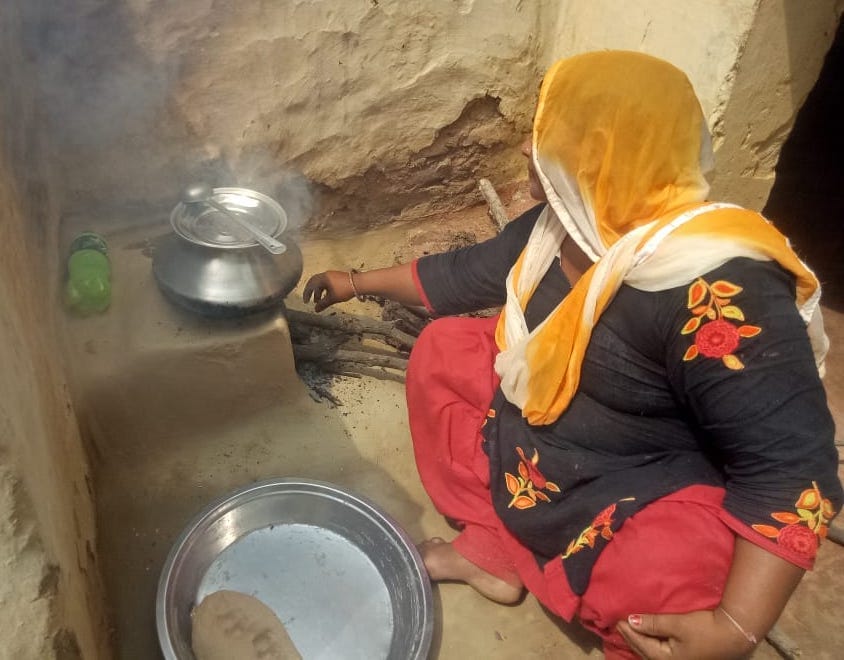 झिंझाना में चूल्हे पर खाना बनाती महिला।