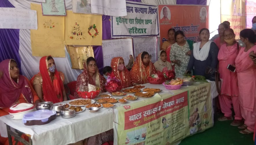 नजीबाबाद में गर्भवती महिलाओं की गोद भराई करातीं आंगनबाड़ी कार्यकर्ता।
