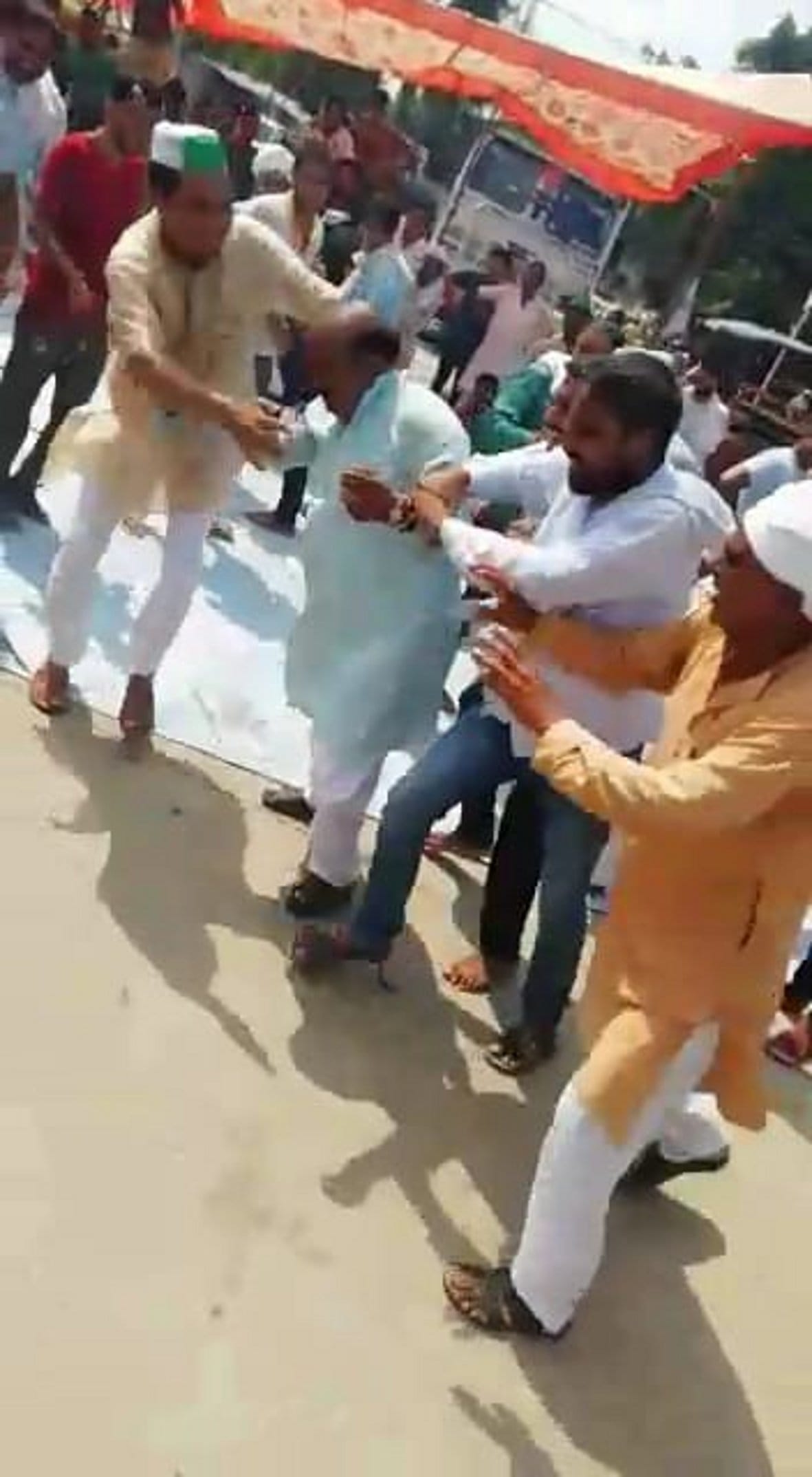 कपड़े में आग लगने के बाद दाहा गांव में  रालोद के जिला महासचिव तेजपाल सिंह को संभालते लोग