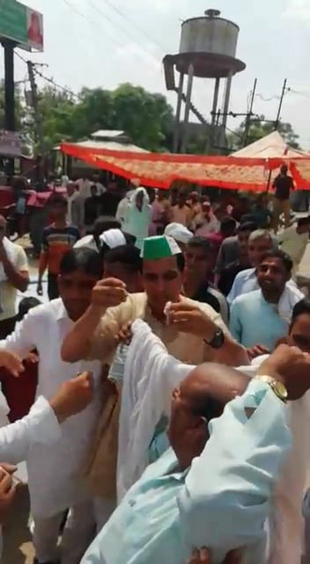 दाहा गांव में  रालोद के जिला महासचिव तेजपाल सिंह के कपड़े में आग लगाते हुए