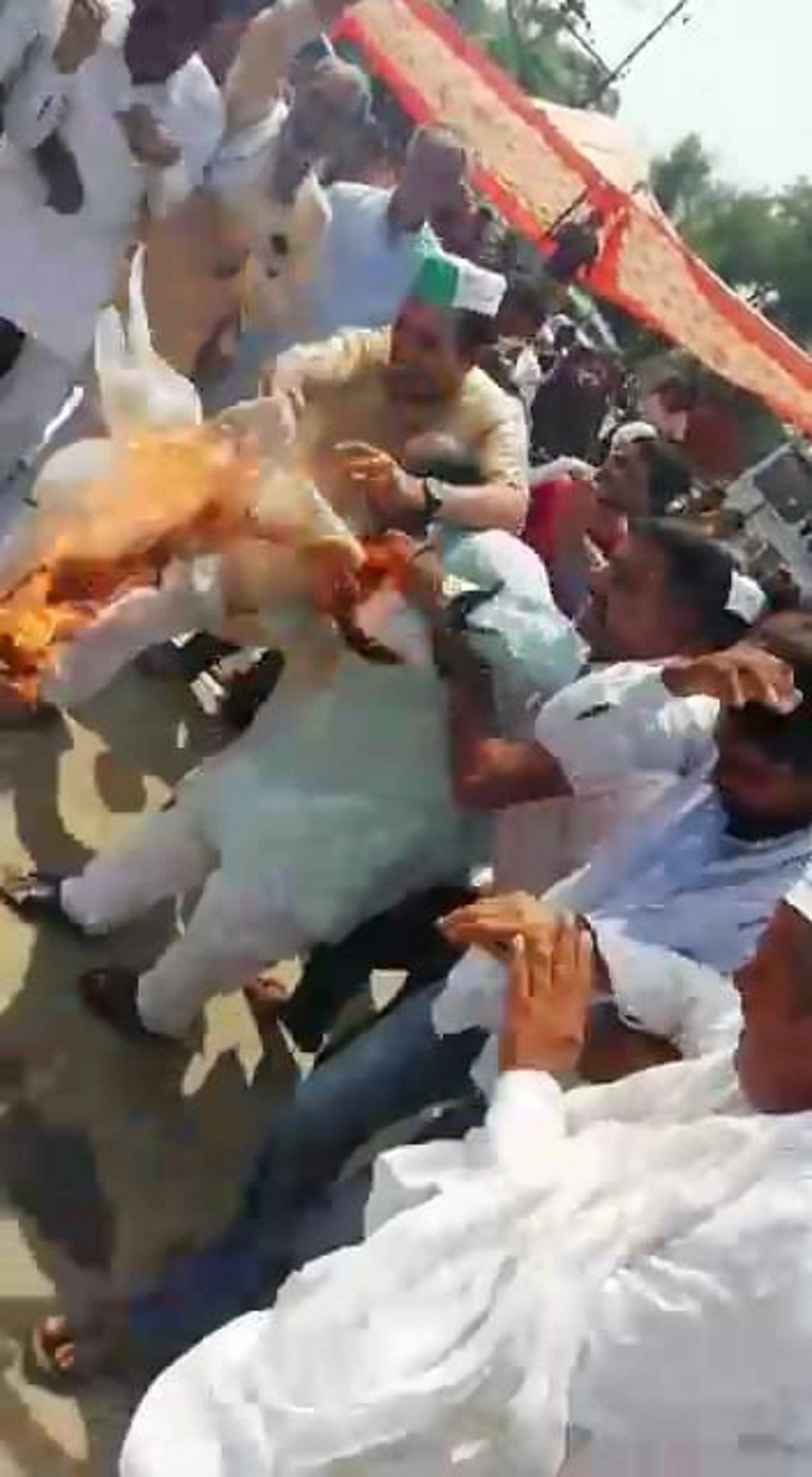 दाहा गांव में  रालोद के जिला महासचिव तेजपाल सिंह के कपड़े में लगी आग को बुझाने की कौशिश करते लोग