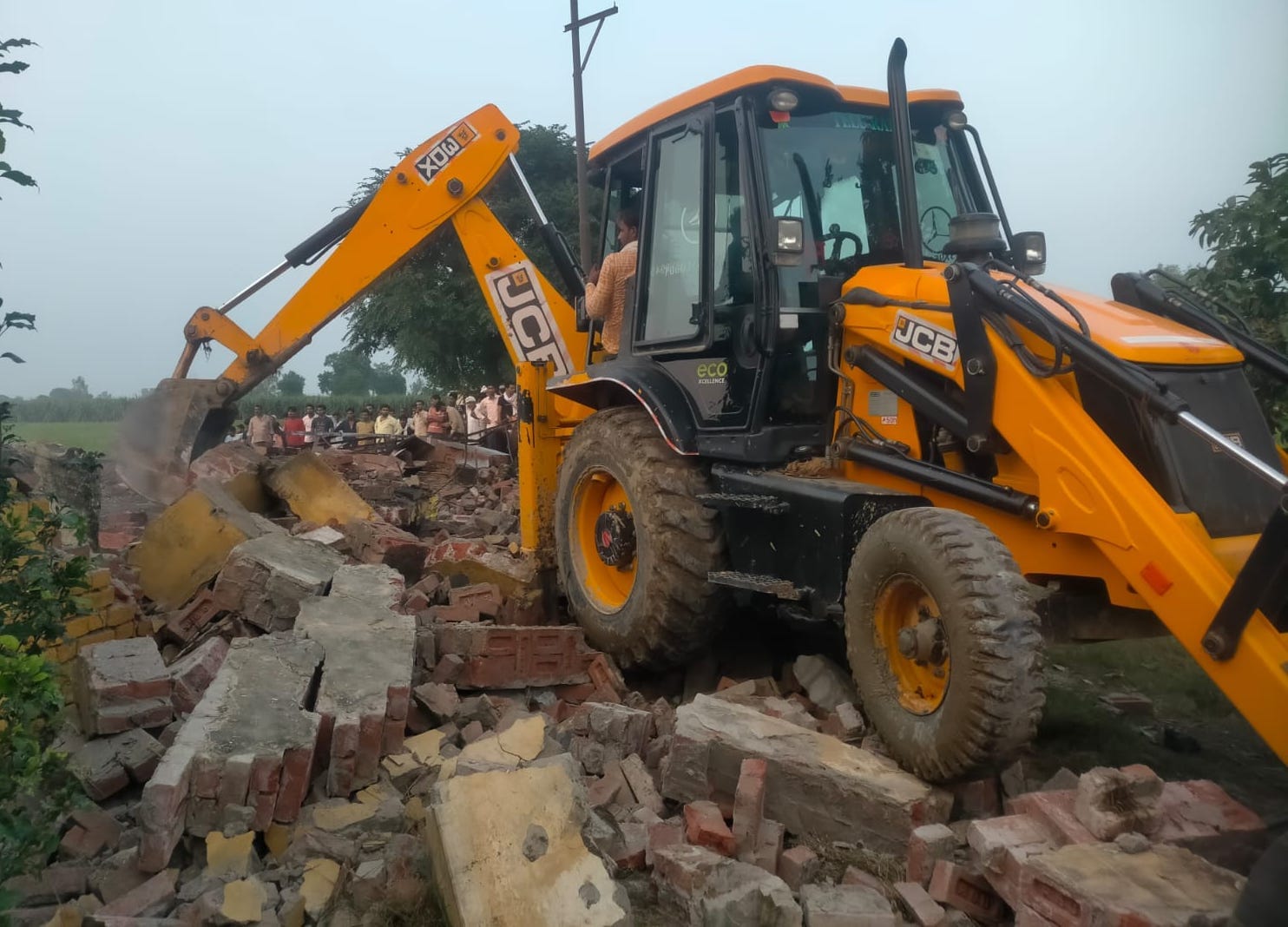 कैराना में पटाखा फैक्टरी में विस्फोट के बाद पड़े मलबे को जेसीबी से हटाते कर्मचारी।