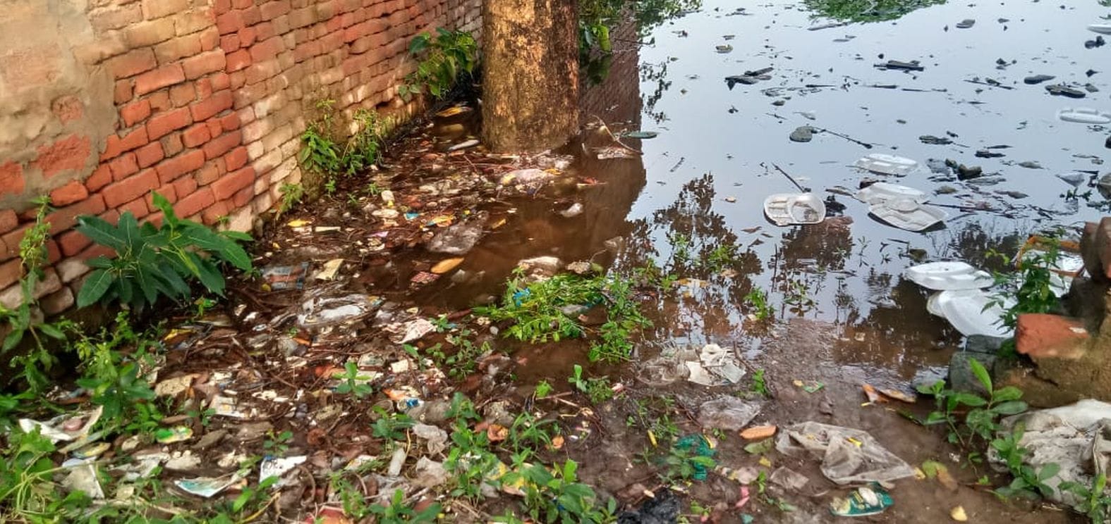 नवाबगंज की बरतल वाली गली में भरे पानी में पड़ा कूड़ा। संवाद