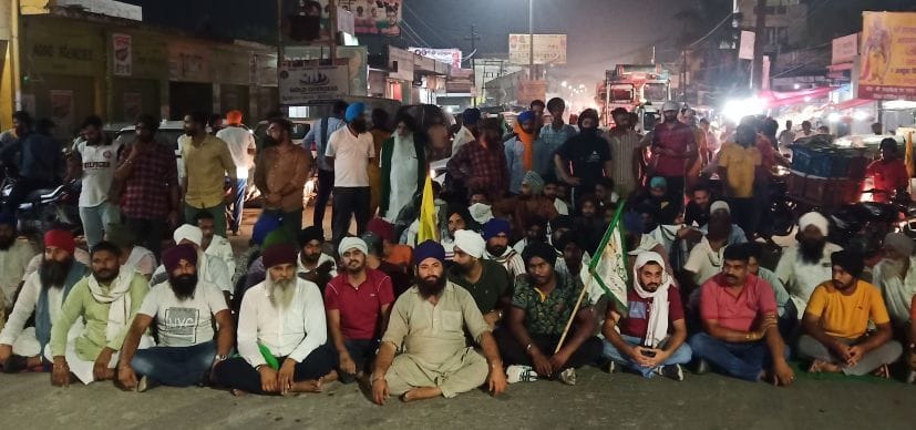 गदरपुर में एनएच 74 जाम कर धरने पर बैठे किसान।