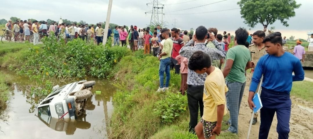 लालपुर गांव के पास पानी भरे खड्ड में पलटी पड़ी बच्चों से भरी वैन व मौजूद ग्रामीण। (संवाद)