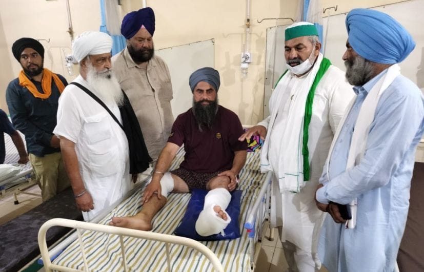 रुद्रपुर के निजी अस्पताल में भर्ती घायल किसान का हाल जानते राकेश टिकैत।