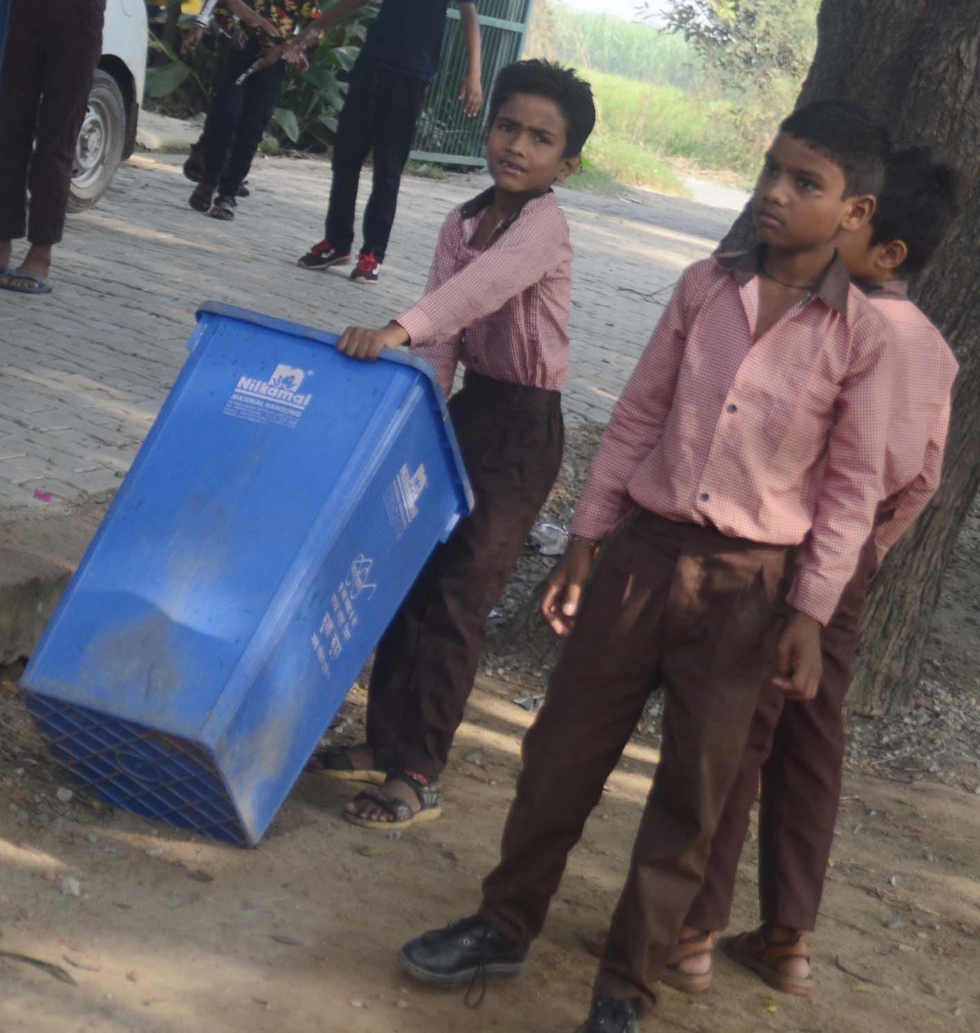 बागपत के अहैड़ा गांव स्थित प्राथमिक विद्यालय में कूड़ा उठाता छात्र