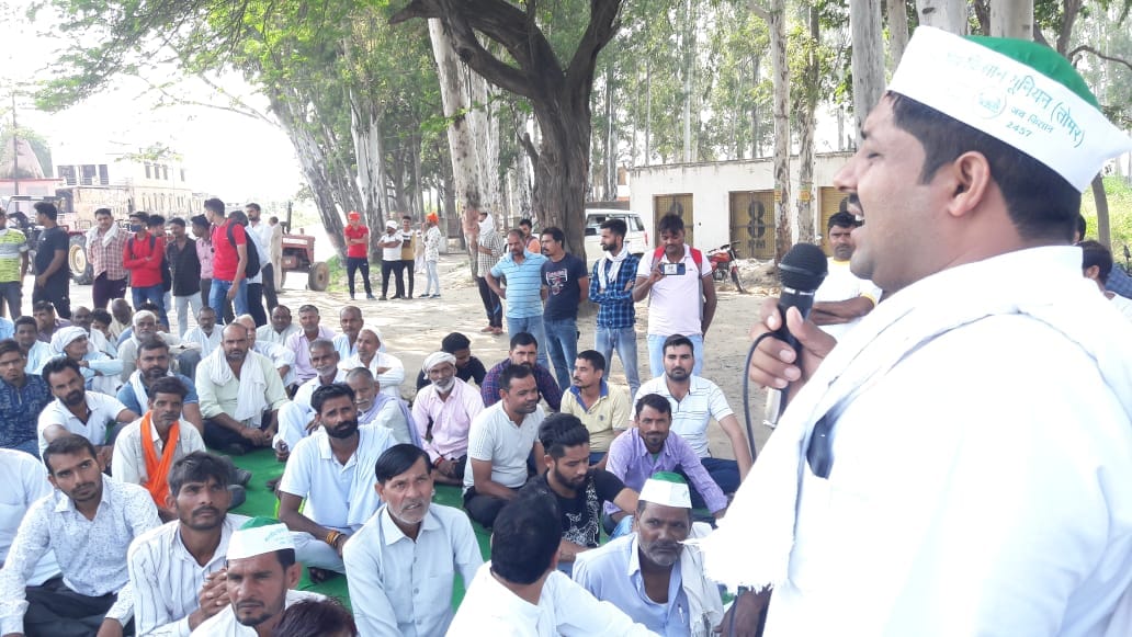 खतौली हाईवे पर जाम लगाकर धरने पर बैठे किसान।