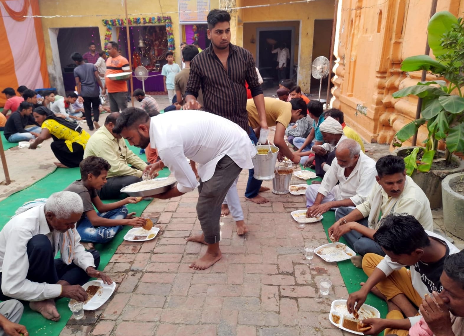 हल्दौर में दुर्गा नवमी पर बड़ा शिव मंदिर पर भंडारे में प्रसाद ग्रहण करते श्रृदालु।