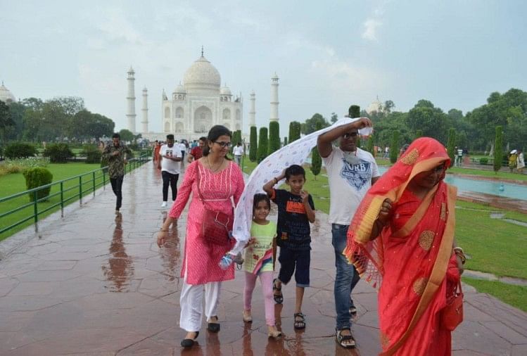 आगरा: ताजमहल पर बारिश से बचते पर्यटक