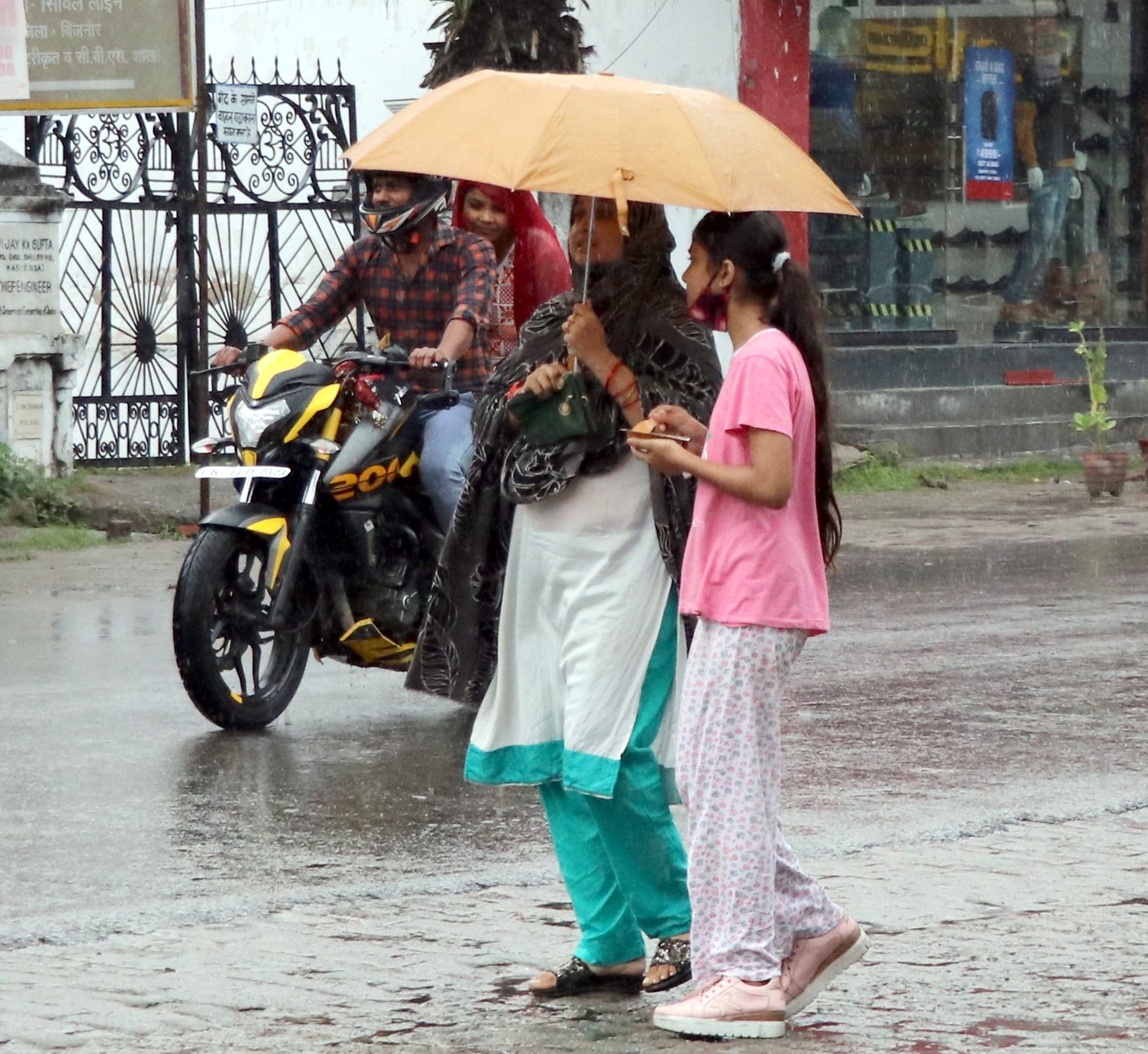 बिजनौर में रविवार को हुई बारिश में छाता लगाकर जाती महिला और युवती। बिजनौर में रविवार को हुई बारिश में छाता लगाकर जाती महिला और युवती।