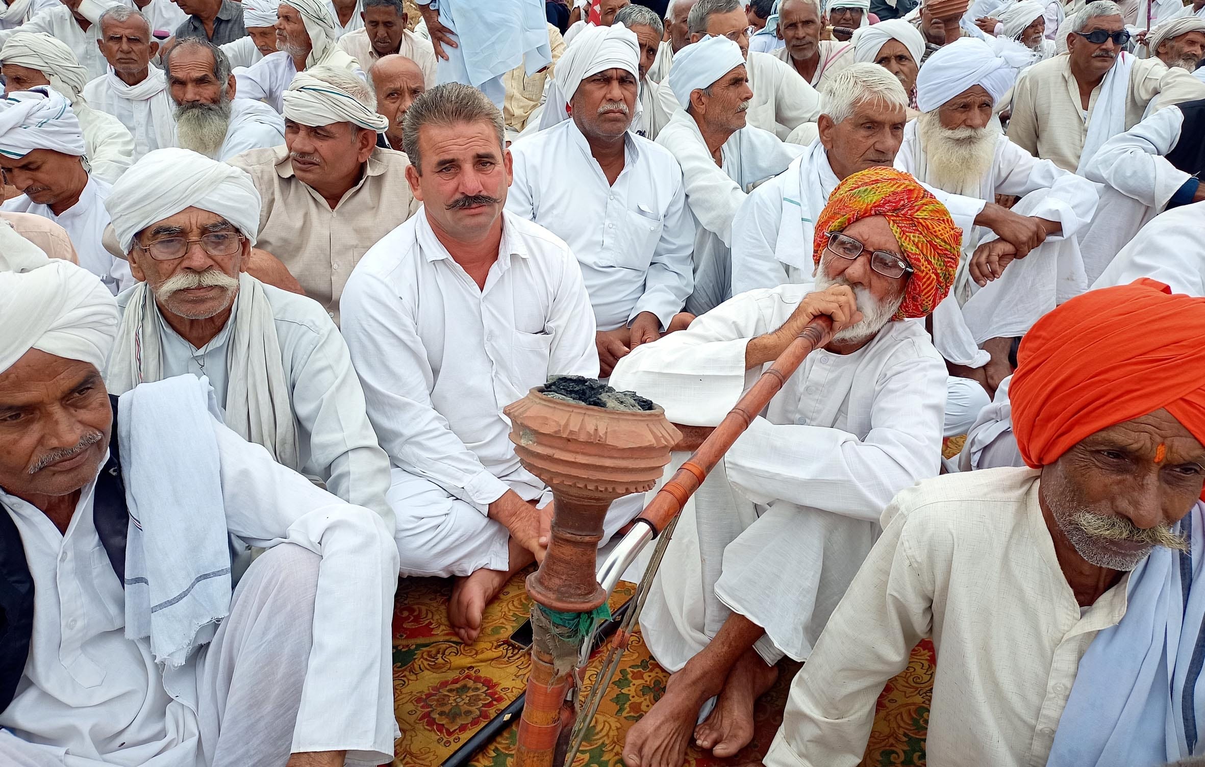 हुक्का की गुड़गुड़ाहड़ के साथ रेल की पटरियों पर धरना देते किसान। हुक्का की गुड़गुड़ाहड़ के साथ रेल की पटरियों पर धरना देते किसान।