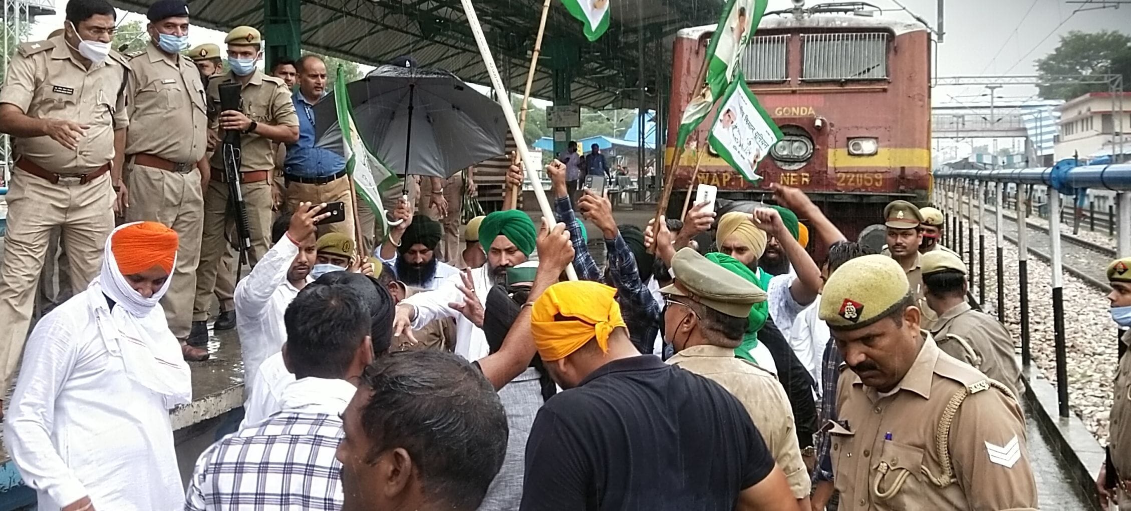 जंक्शन पर खड़ी ट्रेन के आगे ट्रैक पर खड़े होकर विरोध जताते किसान। संवाद जंक्शन पर खड़ी ट्रेन के आगे ट्रैक पर खड़े होकर विरोध जताते किसान। संवाद