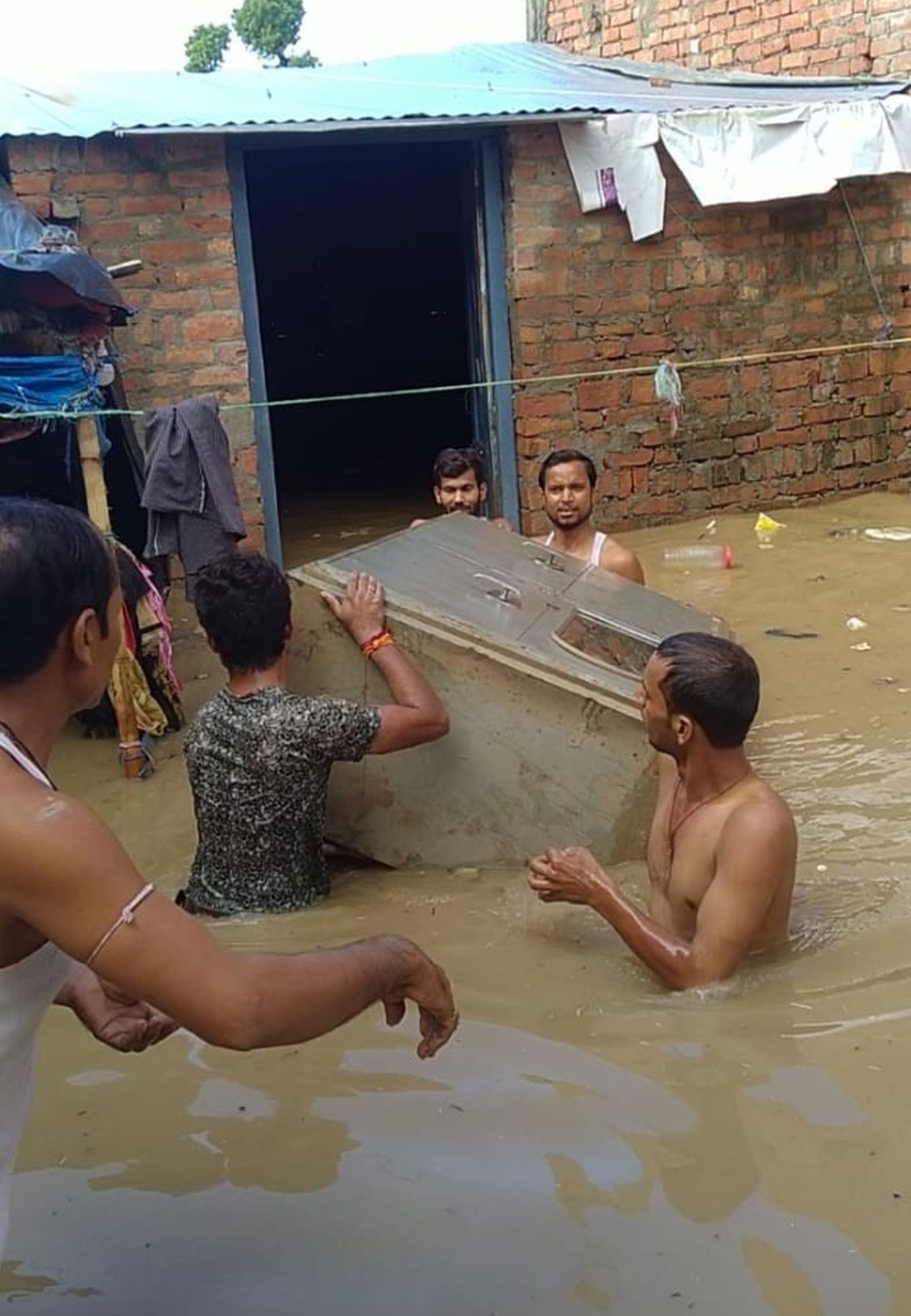 शहर के मोहल्ला भोपत पट्टी में घर में भरे बारिश के पानी से सामान निकालते परिजन। संवाद शहर के मोहल्ला भोपत पट्टी में घर में भरे बारिश के पानी से सामान निकालते परिजन। संवाद