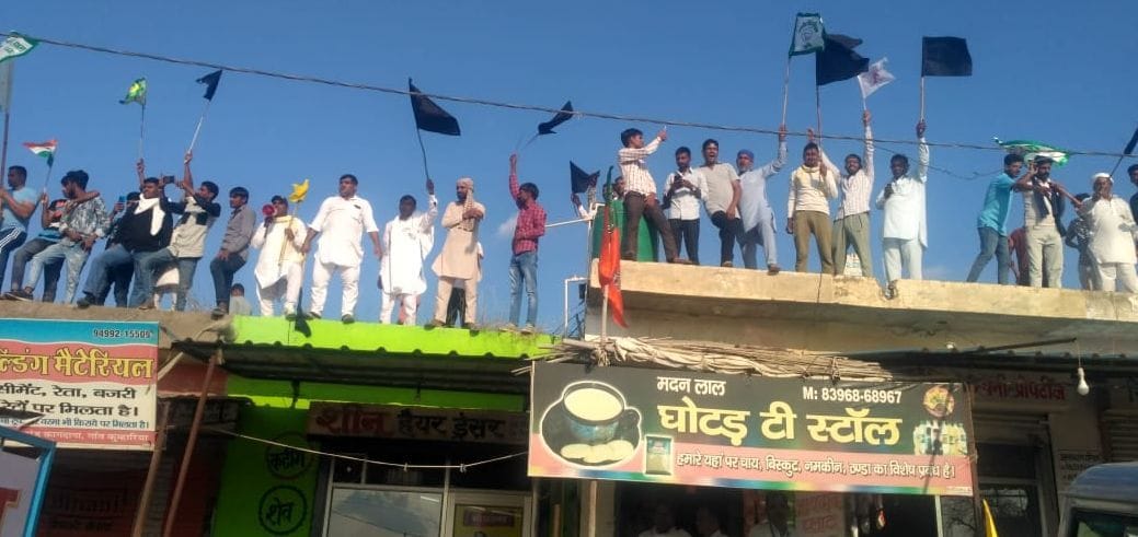 जनसभा के सामने दुकानों की छतों पर चढ़कर भाजपा नेताओं को काले झंडे दिखाते किसान जनसभा के सामने दुकानों की छतों पर चढ़कर भाजपा नेताओं को काले झंडे दिखाते किसान