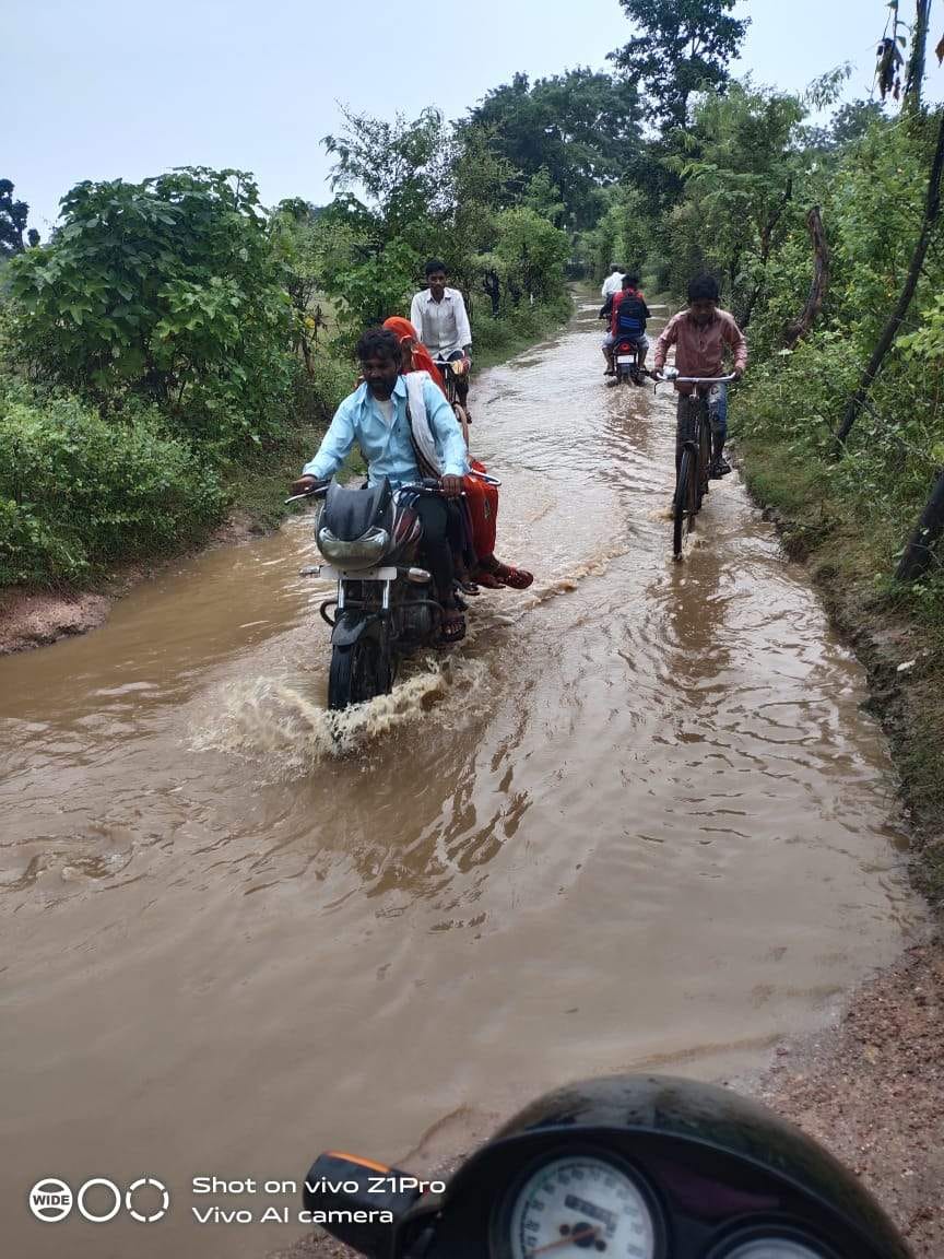 ग्राम गैंदोरा से धनगौल जाने वाले संपर्क मार्ग पर भरे पानी से निकलते लोग